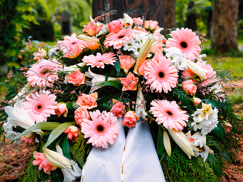 Pastellfarbene Blumen schmücken ein Grab auf dem Friedhof und symbolisieren Erinnerung, Trost und würdevollen Abschied bei einer Erdbestattung in Dortmund.