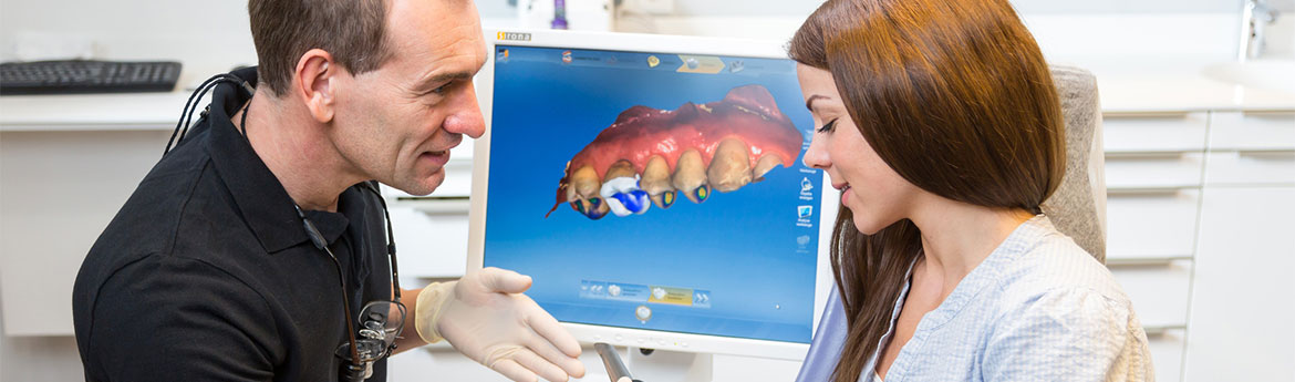 Zahnarzt, der einen Patienten bezüglich der CEREC®-Zahntechnologie berät