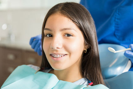 Portrait von lächelnden Tennager Mädchen mit Zahnspange in Klinik