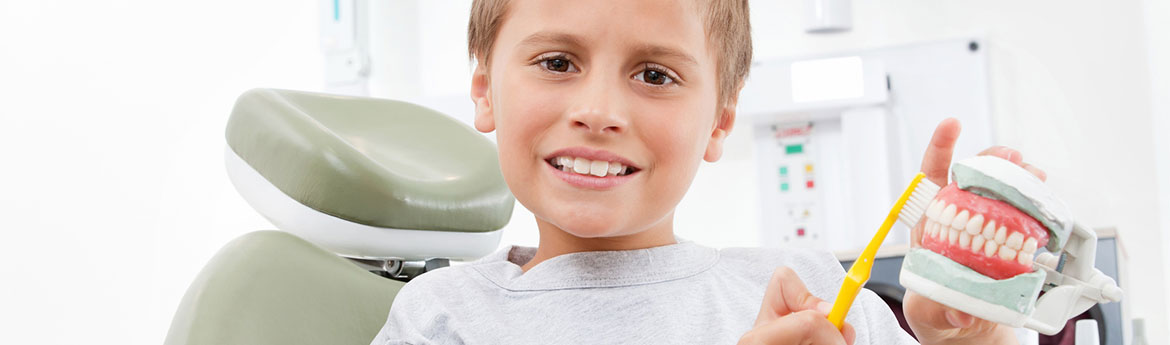 Kind beim Zahnarzt mit Zahnbürste