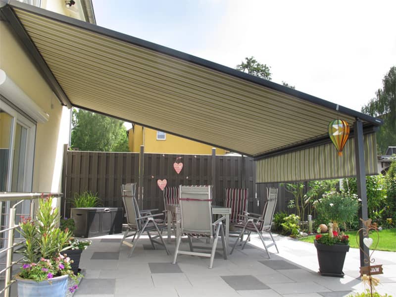 Große, beige gestreifte Terrassenmarkise bietet Schatten über Sitzgruppe – inspirierendes Beispiel für Markisen in Dortmund kaufen für Gartenkomfort.
